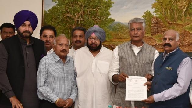 (From right) Punjab governor VP Singh Badnore receives a memorandum addressed to the President from state Congress president Sunil Jakhar, CM Capt Amarinder Singh, and ministers, including Brahm Mohindra and Navjot Singh Sidhu, at the Raj Bhawan in Chandigarh on Friday(HT Photo)