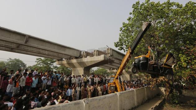 A crane is used to lift an auto rickshaw that got crushed after a highway overpass being built collapsed in Varanasi, Uttar Pardesh, on May 16, 2018. (Rajesh Kumar Singh / AP) A crane is used to lift an auto rickshaw that got crushed after a highway overpass being built collapsed in Varanasi, Uttar Pardesh, on May 16, 2018. (Rajesh Kumar Singh / AP)