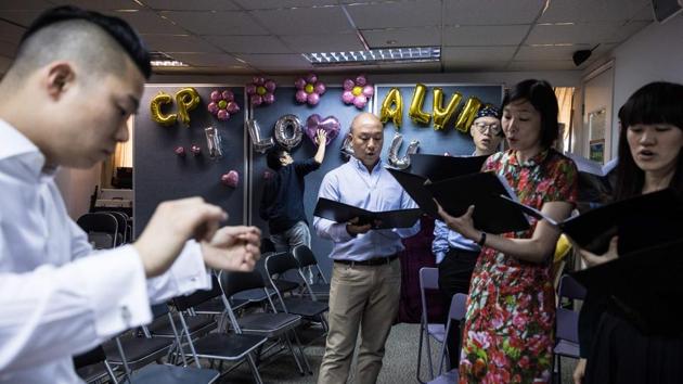 Choir members rehearse as a man sets up balloons before the ceremony. Apprehensive about holding their wedding ceremony in the socially conservative city a year after they signed marriage papers in Britain, Chan and So were finally convinced by their pastor to hold a small-scale celebration. (Dale De La Rey / AFP) Choir members rehearse as a man sets up balloons before the ceremony. Apprehensive about holding their wedding ceremony in the socially conservative city a year after they signed marriage papers in Britain, Chan and So were finally convinced by their pastor to hold a small-scale celebration. (Dale De La Rey / AFP)