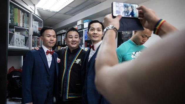 C.P. So (centre R) and Alvin Chan (L) pose for a photograph with pastor Joe Pang before their ceremony. Like many other gay weddings in Hong Kong, this one was held behind closed doors, tucked away in a commercial space. Same-sex marriage is not legally recognised in Hong Kong and often those who have a ceremony say they prefer to do it away from the public gaze. (Dale De La Rey / AFP) C.P. So (centre R) and Alvin Chan (L) pose for a photograph with pastor Joe Pang before their ceremony. Like many other gay weddings in Hong Kong, this one was held behind closed doors, tucked away in a commercial space. Same-sex marriage is not legally recognised in Hong Kong and often those who have a ceremony say they prefer to do it away from the public gaze. (Dale De La Rey / AFP)