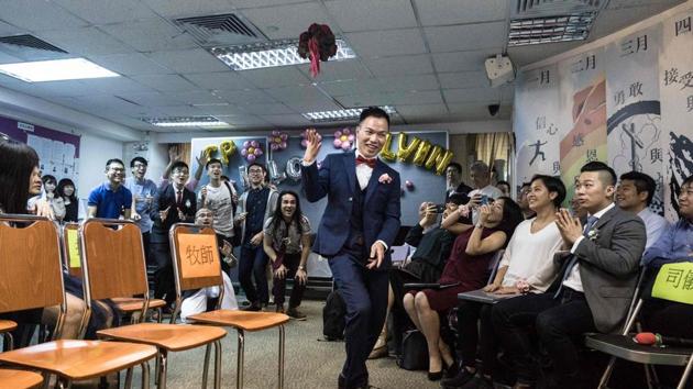 Alvin Chan throws a bouquet of flowers during his wedding ceremony. “The road they’ve walked has been difficult, and I think society has a responsibility to listen to gay people,” Chan told AFP. Outlawing discrimination based on sexual orientation has been proposed in the city’s legislature, but is yet to materialise. (Dale De La Rey / AFP) Alvin Chan throws a bouquet of flowers during his wedding ceremony. “The road they’ve walked has been difficult, and I think society has a responsibility to listen to gay people,” Chan told AFP. Outlawing discrimination based on sexual orientation has been proposed in the city’s legislature, but is yet to materialise. (Dale De La Rey / AFP)