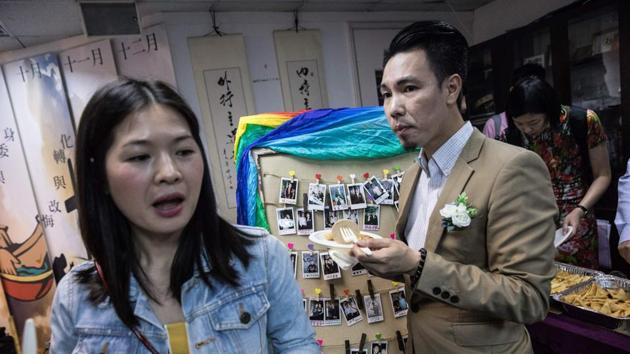 Guests eat next to a board of Polaroid photographs. The Hong Kong government is currently appealing a landmark court decision to grant a British lesbian the spousal right to live and work in the territory. (Dale De La Rey / AFP) Guests eat next to a board of Polaroid photographs. The Hong Kong government is currently appealing a landmark court decision to grant a British lesbian the spousal right to live and work in the territory. (Dale De La Rey / AFP)