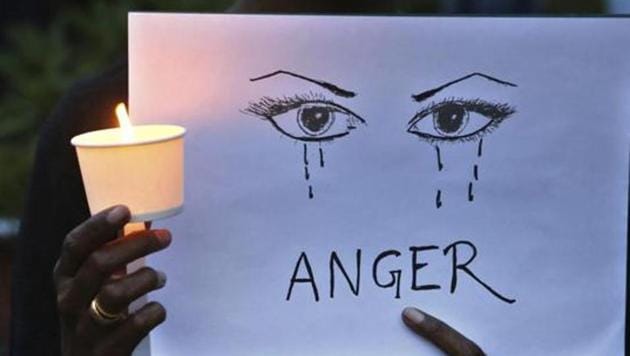 A woman holds a candle and placard seeking an end to sexual violence against women. (AP File Photo) A woman holds a candle and placard seeking an end to sexual violence against women. (AP File Photo)