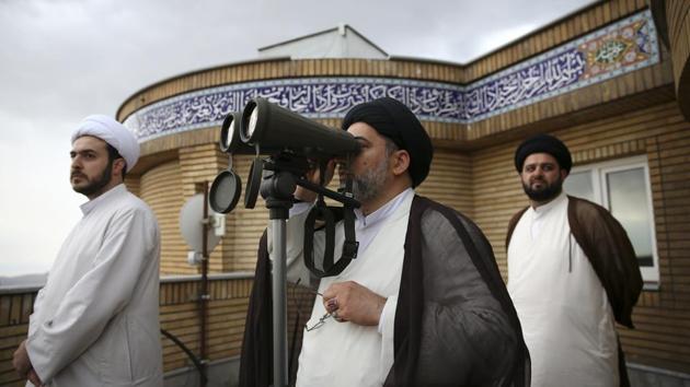 A cleric looks through binoculars for the new moon that signals the start of the Islamic month of Ramadan, at the Imam Ali observatory in Qom, Iran. Some prefer the many advances in technology for predicting the sighting; others would rather stick to tradition, relying on the naked eye. (Vahid Salemi / AP) 