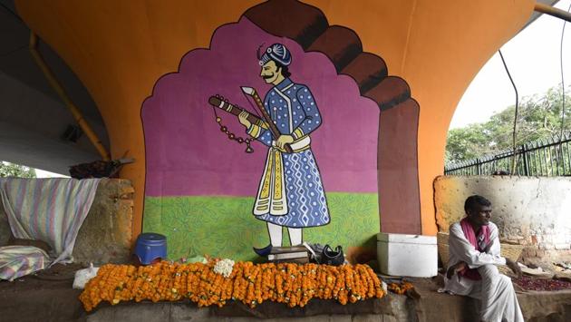 A flower vendor sits under a mural depicting a medieval musician. Meant for the beautification of the area, the murals are part of a clean up which also intends to remove encroachments. (Sanchit Khanna / HT Photo) A flower vendor sits under a mural depicting a medieval musician. Meant for the beautification of the area, the murals are part of a clean up which also intends to remove encroachments. (Sanchit Khanna / HT Photo)