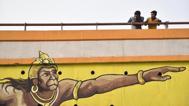 Passersby peer over the flyover across the Old Hanuman Mandir at Yamuna Bazar near Kashmere Gate in Delhi. Arm outstretched, his iconic mace in hand, this mural of the Hindu god Hanuman is among artwork that greets passing traffic. (Sanchit Khanna / HT Photo) Passersby peer over the flyover across the Old Hanuman Mandir at Yamuna Bazar near Kashmere Gate in Delhi. Arm outstretched, his iconic mace in hand, this mural of the Hindu god Hanuman is among artwork that greets passing traffic. (Sanchit Khanna / HT Photo)