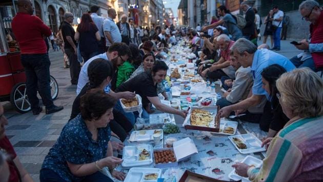 People break their fast near Taksim Square in Istanbul, Turkey. Iftar is a social event as much as it is a gastronomical adventure. (Yasin Akgul / AFP) 