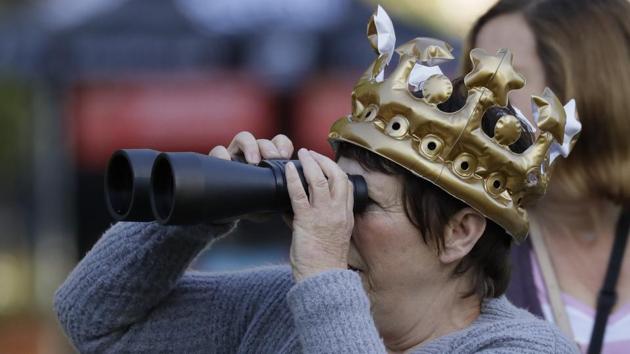 A woman with an inflatable crown looks through binoculars with just hours left to go for Prince harry and Meghan Markle’s wedding ceremony at St. George's Chapel in Windsor Castle in Windsor, England. Britain’s Prince Harry and US actress Meghan Markle, who announced their engagement in late November 2017, are all set for their big day and the world’s watching. (Kristy Wigglesworth / AP)