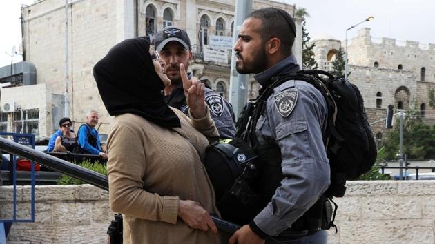 An Israeli police officer argues with a Palestinian woman outside Jerusalem's Old City's Damascus Gate. (Ammar Awad / REUTERS) An Israeli police officer argues with a Palestinian woman outside Jerusalem's Old City's Damascus Gate. (Ammar Awad / REUTERS)
