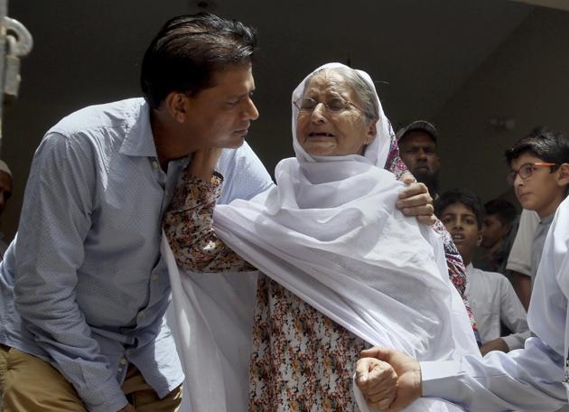 Abdul Aziz Sheikh, left, father of Sabika Sheikh, a victim of a shooting at a Texas high school, comforts to an elderly woman arriving for condolence to his daughter at his home in Karachi, Pakistan, Saturday, May 19, 2018.(AP)