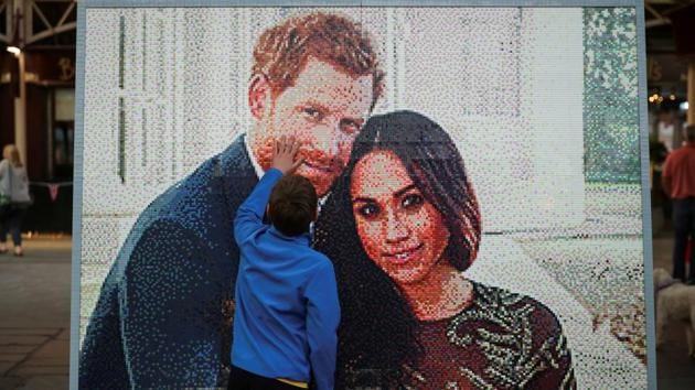 A boy touches a LEGO brick mosaic of Britain's Prince Harry and Meghan Markle in Windsor, Britain, on May 18, 2018. The hour-long ceremony will begin at 1100 GMT (3:30pm IST). (Reuters)