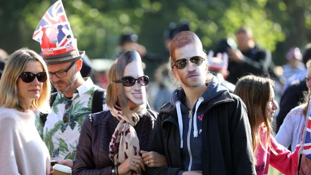 Spectators wear cardboard cut out face masks of Meghan Markle, center, and Prince Harry, right, during the wedding of Prince Harry and Meghan Markle on the Long Walk in Windsor, U.K. on Saturday May 19, 2018. (Bloomberg)