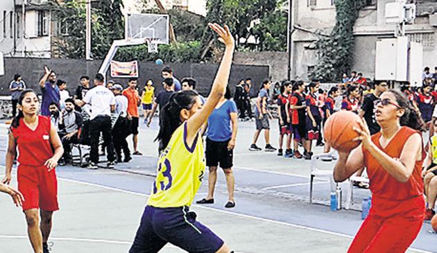 Players of Deccan B (yellow) and SKP (red) during a match at the seventh late Sanjay Mahadeo Nimhan memorial basketball tournament.(HT PHOTO)