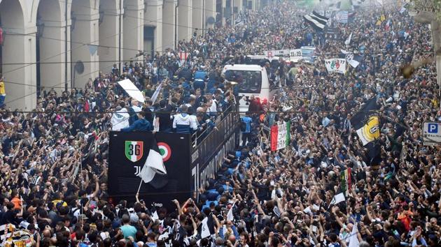 Juventus players celebrate on an open bus after clinching the Serie A title for a record extending seventh successive time in Turin on Saturday.(AP)