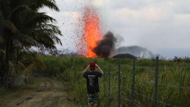 A man takes a photo of a lava fountain from a Kilauea volcano fissure on Hawaii's Big Island on May 18.(AFP Photo) A man takes a photo of a lava fountain from a Kilauea volcano fissure on Hawaii's Big Island on May 18.(AFP Photo)