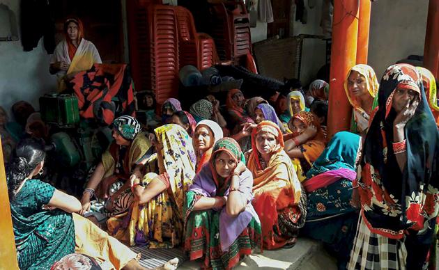 Grieving women in MAdhauli village where six persons died after consuming spurious liquor, in Kanpur Dehat.(PTI Photo)