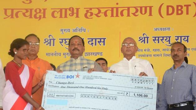 Chief minister Raghubar Das giving a cheque to a beneficiary during the inaugural function of Direct Benefit Transfer (DBT) scheme under food security at Nagri in Ranchi on October 4,2017.(HT File Photo)