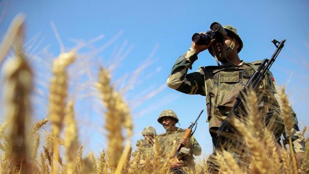 BSF personnel uses binoculars to maintain vigil along the international border in Jammu.(PTI File Photo)