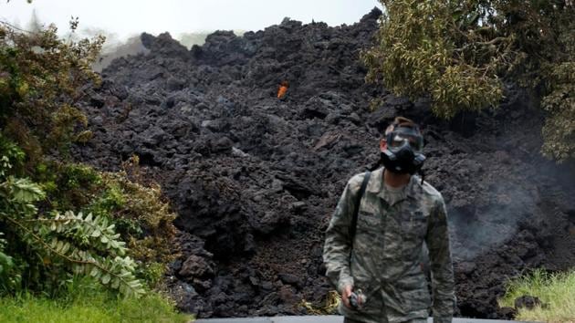 Senior Airman John Linzmeier, of the Hawaii National Guard, walks away from a lava flow on Highway 137 south-east of Pahoa. The occurrence of new lava-spewing vents, now numbering at least 22, have been accompanied by flurries of earthquakes and periodic eruptions of ash, volcanic rock and toxic gases from the volcano’s crater. (Terray Sylvester / REUTERS) Senior Airman John Linzmeier, of the Hawaii National Guard, walks away from a lava flow on Highway 137 south-east of Pahoa. The occurrence of new lava-spewing vents, now numbering at least 22, have been accompanied by flurries of earthquakes and periodic eruptions of ash, volcanic rock and toxic gases from the volcano’s crater. (Terray Sylvester / REUTERS)