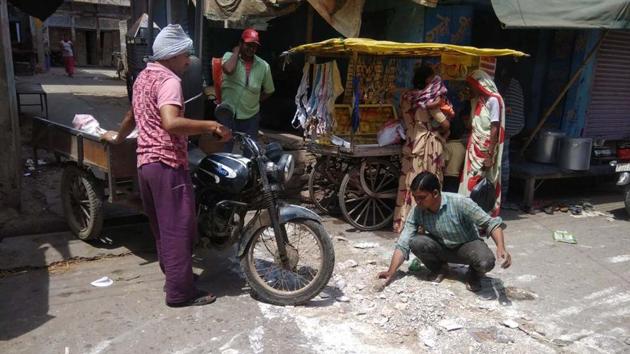 Nand Kishor Saini fills a pothole on a street in Bharatpur.(HT Photo)