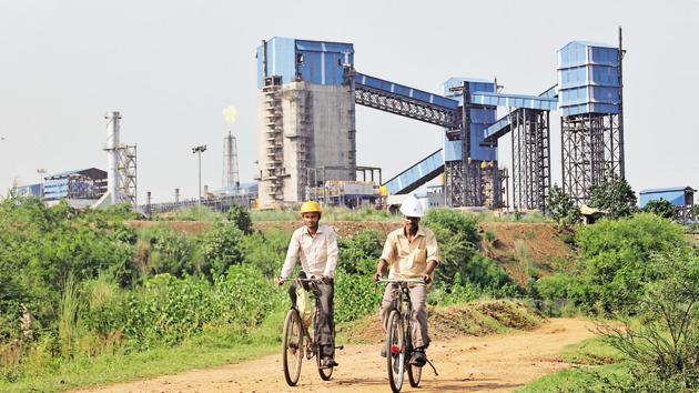 Men ride their bicycles in front of the Bhushan Steel plant in the eastern Indian state of Odisha(REUTERS File Photo)