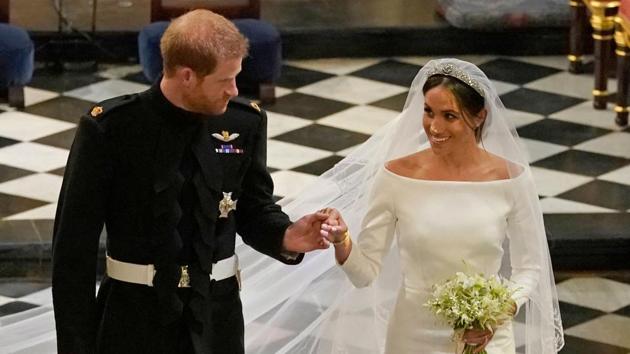 Britain's Prince Harry, Duke of Sussex (L) and Britain's Meghan Markle, Duchess of Sussex, (R) walk away from the High Altar toward the West Door to exit at the end of their wedding ceremony in St George's Chapel, Windsor Castle, in Windsor, on May 19, 2018.(AFP)