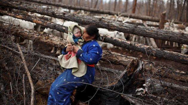 Ethnic Dukha nomad Jargal Gombosed holds her grandchild outside her family's reindeer pen. The Dukha, around 280 of them, are spread out across 59 households. The meat in their diet comes from game hunted around the Taiga. In 2012, Mongolia’s government designated the majority of their traditional herding grounds as part of a national park in an attempt to protect a ravaged ecosystem. (Thomas Peter / REUTERS) Ethnic Dukha nomad Jargal Gombosed holds her grandchild outside her family's reindeer pen. The Dukha, around 280 of them, are spread out across 59 households. The meat in their diet comes from game hunted around the Taiga. In 2012, Mongolia’s government designated the majority of their traditional herding grounds as part of a national park in an attempt to protect a ravaged ecosystem. (Thomas Peter / REUTERS)