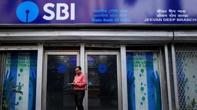 A man checks his mobile phones in front of State Bank of India (SBI) branch in Kolkata, India.(REUTERS File Photo)