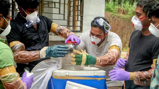 Kerala animal husbandry department and forest officials deposit a bat into a container after catching it inside a well at Changaroth in Kozhikode on May 21, 2018.(PTI Photo)