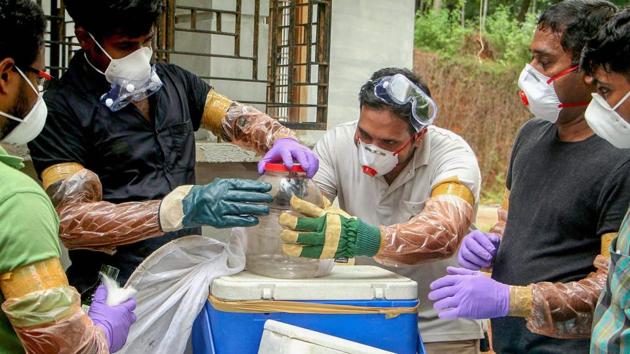 Animal Husbandry department and forest officials collect bats from a well of a house after the outbreak of 'Nipah' virus, near Perambra in Kozhikode on Monday.(PTI)