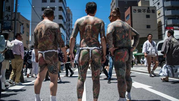The festival is a rare show of strength when gang members strip down to their fundoshi (sumo underwear) and make their presence known in the crowds. One hundred Yakuza members rally together to carry their own portable shrine and gang members also pose for the public showing off their body art. (Carl Court / Getty Images) The festival is a rare show of strength when gang members strip down to their fundoshi (sumo underwear) and make their presence known in the crowds. One hundred Yakuza members rally together to carry their own portable shrine and gang members also pose for the public showing off their body art. (Carl Court / Getty Images)