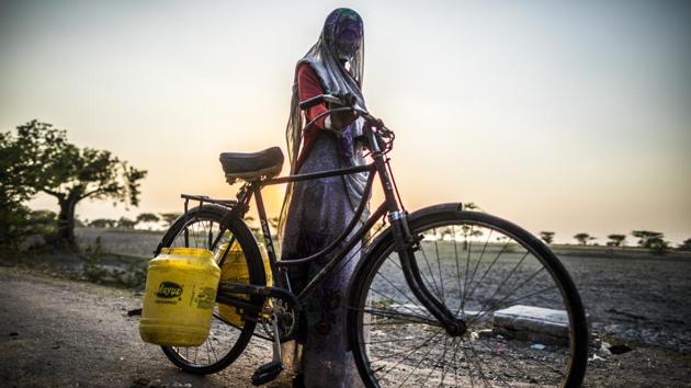 Pappi Pal, 22, shares Golaniya’s experience in Chamraha village. The village’s wells have dried down and its few hand pumps are shared between hundreds of families. Those well off have dug deep borewells, further depleting groundwater levels. Pappi Pal complains of leg ailments form the multiple trips daily and has had to resort to using a bicycle to ease the strain. (Prashanth Vishwanathan / WaterAid)