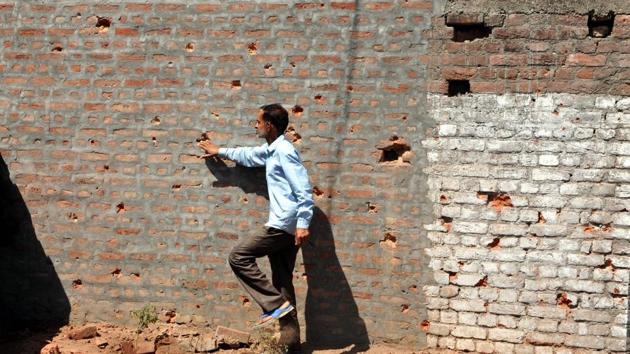 A border villager inspects the wall of a building damaged by shelling from the Pakistani side of the border in Nanga village of Ramgarh sector, around 45 km from Jammu, on May 23, 2018. (Nitin Kanotra/HT Photo)