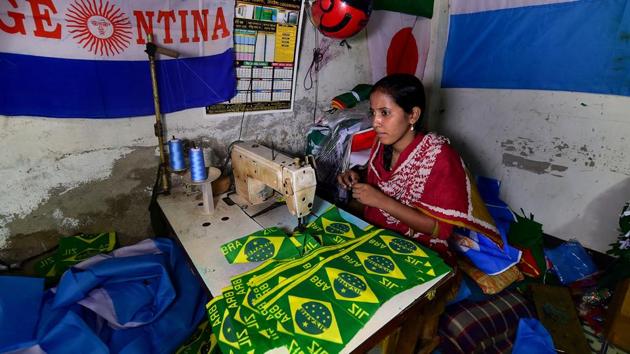 This photograph taken on May 17, 2018 shows a Bangladeshi worker sewing flags for FIFA World Cup football playing nations in Narayanganj, on the outskirts of Dhaka, ahead of Russia 2018.(AFP)