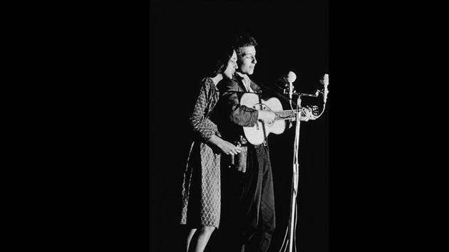 Joan Baez and Bob Dylan perform onstage, 1963. A relatively unknown Bob Dylan debuted at the 1963 Newport Festival performing two duets with Baez, one on her and another on his own set. Joining Baez’s August tour later, introduced Dylan to the large audiences her fame pulled, playing a large role in his early rise to success. The next two years saw tables turning between them. (Columbia Records / Getty Images)