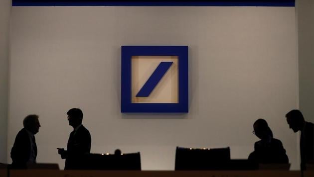 People are silhouetted next to the Deutsche Bank's logo prior to the bank's annual meeting in Frankfurt, Germany, May 24, 2018. REUTERS/Kai Pfaffenbach(REUTERS File Photo)