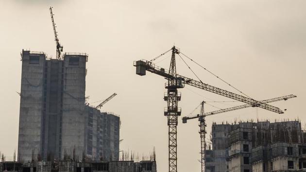 Tower cranes operate in a residential building construction site at a Jaypee Infratech Ltd project in Noida, Uttar Pradesh.(Prashanth Vishwanathan/Bloomberg)