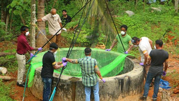 Animal husbandry department and forest officials inspect a well to catch bats at Changaroth in Kozhikode in Kerala.(AFP Photo)