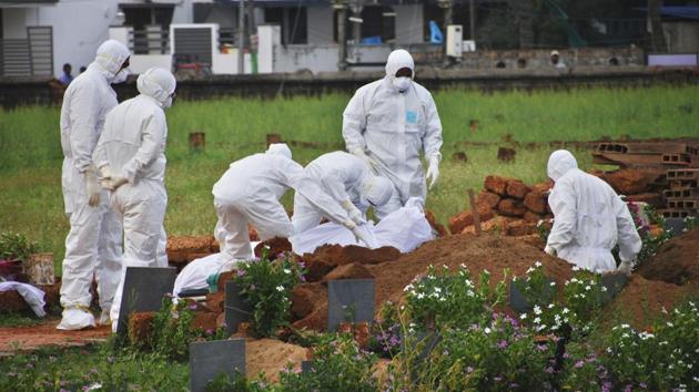 Paramedics wear protective suits as a precautionary measure against the Nipah virus as they bury a patient, died of the same virus, in Kozhikode on May 24.(AP Photo) Paramedics wear protective suits as a precautionary measure against the Nipah virus as they bury a patient, died of the same virus, in Kozhikode on May 24.(AP Photo)