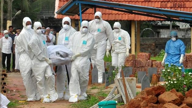 Doctors and relatives wearing protective gear carry the body of a victim, who lost his battle against the Nipah virus, during his funeral at a burial ground in Kozhikode on May 24.(REUTERS)