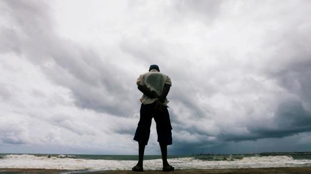 A man looks at the rough sea as rainy clouds gather above during the monsoon period in Colombo, Sri Lanka. (Dinuka Liyanawatte / REUTERS)