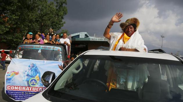 Nepalese veteran Sherpa guide, Kami Rita, 48, waves as he arrives in Kathmandu, Nepal after having scaled Mount Everest on May 16 for the 22nd time, setting the record for most climbs of the world's highest mountain. (Niranjan Shrestha / AP)