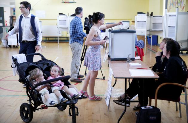 A woman votes while her children wait in their pushchair as Ireland holds a referendum on liberalizing its law on abortion, in Dublin, Ireland, May 25, 2018.(REUTERS Photo)