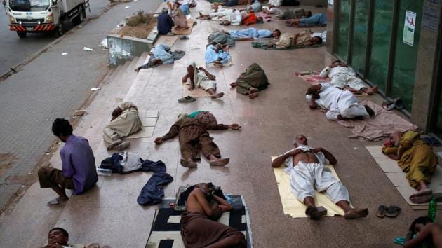 Residents sleep on a building pavement, to escape heat and frequent power outage in their residence area in Karachi, Pakistan. (Akhtar Soomro / REUTERS)
