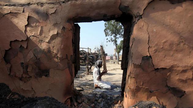 A villager performs prayers outside his house which was gutted, following firing from the Pakistan border, at Jora farm village, in Ranbir Singh Pura district of Jammu on May 24, 2018. (AFP)