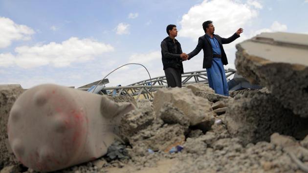 Men inspect a damaged petrol station after it was hit by alleged Saudi-led airstrikes on the outskirts the Yemeni capital Sanaa on May 21, 2018. (AFP)