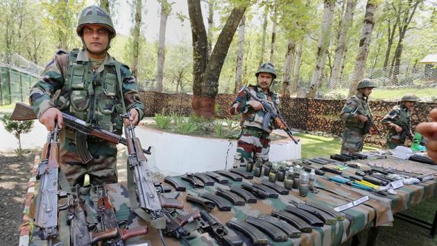 Army personnel display a huge cache of arms and ammunitions recovered from five militants ,who were killed during an encounter, at Tangdar near LoC in north Kashmir on Sunday.(PTI Photo)