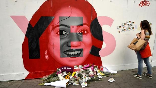 A woman looks at a new mural of Savita Halappanavar with flowers placed beneath it put up on the day of the Abortion Referendum on liberalising abortion laws in Dublin, Ireland May 25, 2018.(REUTERS)