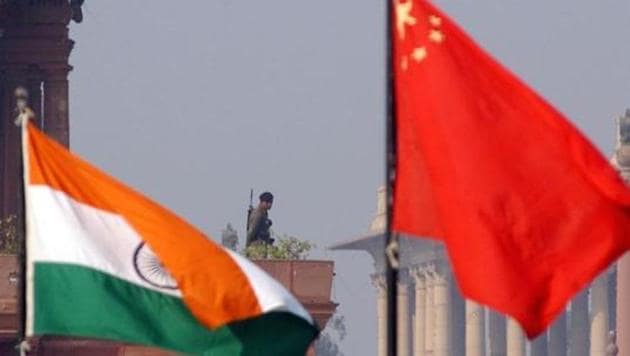 An Indian paramilitary officer is framed by an Indian (L) and Chinese (R) flags as he stands guard near the presidential palace in New Delhi, 12 January 2002. (AFP FIle Photo) An Indian paramilitary officer is framed by an Indian (L) and Chinese (R) flags as he stands guard near the presidential palace in New Delhi, 12 January 2002. (AFP FIle Photo)