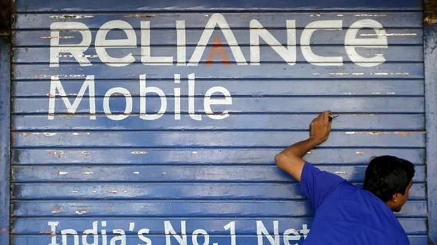 A man opens the shutter of a shop painted with an advertisement of Reliance Communications in Mumbai, India. (Reuters File Photo) A man opens the shutter of a shop painted with an advertisement of Reliance Communications in Mumbai, India. (Reuters File Photo)
